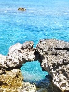 a rock formation in the ocean with blue water at Blaga Apartment - in Korčula