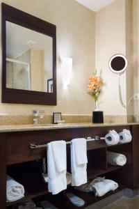 uma casa de banho com lavatório, espelho e toalhas em Best Western PREMIER Monterrey Aeropuerto em Monterrey