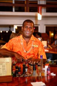 a man sitting at a bar smiling at the camera at Bedarra Beach Inn in Korotogo