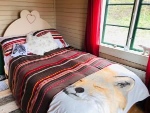 Un dormitorio con una cama con un zorro relleno. en Fisherman s Cottage overlooking the river, en Avesta
