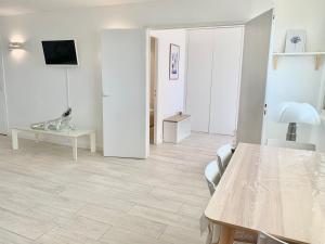 - un salon blanc avec une table et une télévision dans l'établissement Loft Marina direct plage, à Villeneuve-Loubet