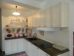 a kitchen with white cabinets and a sink at Apartman Linda in Medulin
