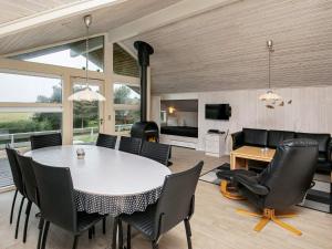 een eetkamer en woonkamer met een tafel en stoelen bij 8 person holiday home in Humble in Humble