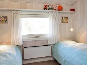 een slaapkamer met 2 aparte bedden en een raam bij 8 person holiday home in Humble in Humble