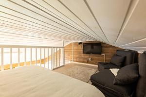 ein Schlafzimmer mit einem Bett, einem TV und einem Sofa in der Unterkunft UnelmaHelmi in Ruka