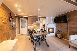 a kitchen and dining room with a table and a fireplace at UnelmaHelmi in Ruka
