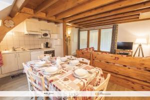 a dining room with a table and a kitchen at La P'tite Marmotte in Gavarnie