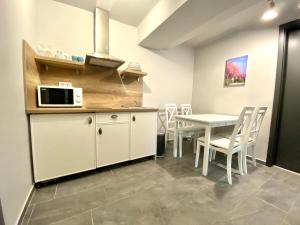 a kitchen and dining room with a table and a microwave at Balkon Apartmanház Panzió in Balatonfüred