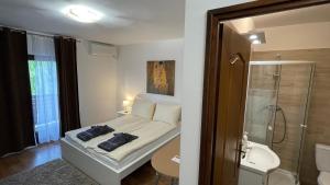 a small bedroom with a bed and a shower at CITY Apartman in Balatonföldvár +29 photos