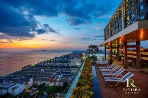 een uitzicht op de oceaan vanuit een gebouw met ligstoelen bij Riviera Jomtien by Zoom Pattaya 2 in Jomtien Beach