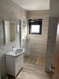 y baño con lavabo y ducha. en Belamionix motel, en Bosanski Šamac