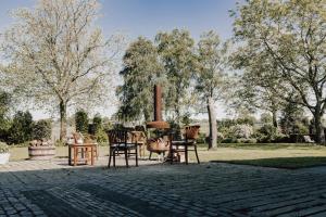 een groep stoelen op een bakstenen patio bij Gastenverblijf de Korenhorst in Lengel