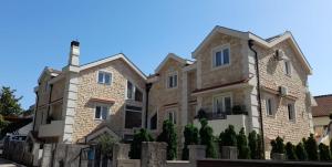 a large stone house with a fence in front of it at 42° North Apartments in Tivat