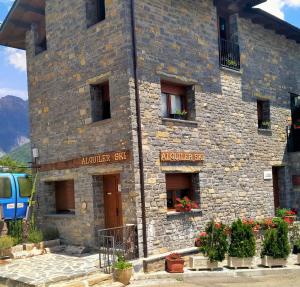 a stone building with flowers in front of it at Apartamentos La Glera Biescas in Biescas
