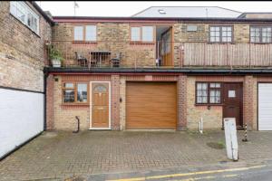 a brick house with two garage doors on a street at Rose Mews Central Broadstairs in Kent