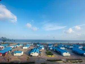 een luchtzicht op een parkeerplaats met blauwe en witte tenten bij Hotel SagarPriya in Digha