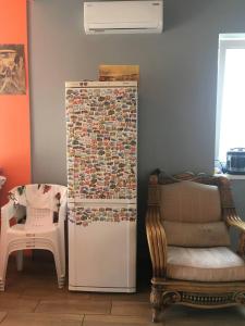 a refrigerator in a room next to a chair and a chair at Villa Bulli in Zatoka
