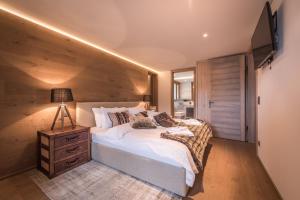 a bedroom with a large bed with a wooden wall at Bergwelt Grindelwald Residence in Grindelwald