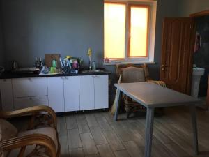 a kitchen with a table and a table and chairs at Villa Bulli in Zatoka