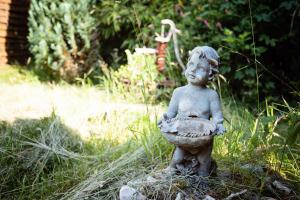 uma estátua de um menino sentado numa pedra em Ferienparadies Mühlenbach em Soltau