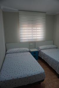 two twin beds in a bedroom with a window at Paradise Nassau Vera Beach in Vera