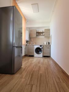a kitchen with a refrigerator and a washing machine at Apartamente Livada in Râmnicu Vâlcea
