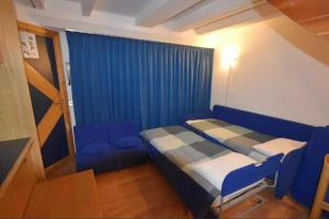 a small room with a bed and a blue curtain at APPARTAMENTO A MADONNA DI CAMPIGLIO in Madonna di Campiglio