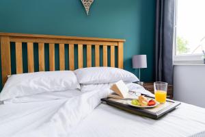 a tray of food and orange juice on a bed at Wingfield Lodge - Near Clay Cross in Chesterfield