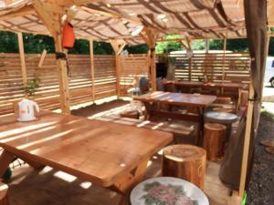 a patio with wooden tables and benches and a wooden umbrella at ペンション　メタセコイア in Aiba