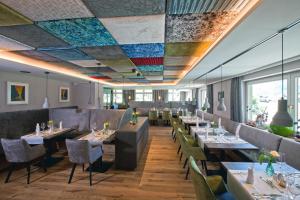 un restaurante con mesas y sillas y un techo colorido en Hotel Truyenhof en Ried im Oberinntal