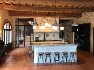 a kitchen with a large island with bar stools at domaine Les Castans in Saint-Thibéry
