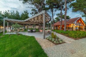 un padiglione con tavoli e sedie di fronte a una casa di Marisstone Hotels a Mecidiye