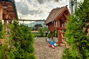 um pequeno parque infantil com uma pequena casa de jogos de madeira em Karczogród em Kościelisko