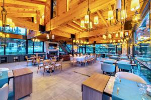 un ristorante con soffitti in legno, tavoli e sedie di Marisstone Hotels a Mecidiye