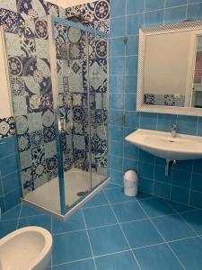 a blue tiled bathroom with a shower and a sink at Music House Palinuro in Palinuro +49 photos