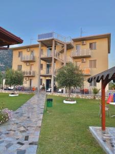 a large apartment building with a lawn in front of it at Vila Hotel in Velipojë