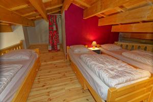 twee bedden in een kamer met een rode muur bij le burel 5 personnes in Lanslevillard