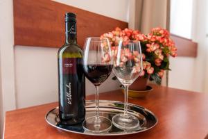 a bottle of wine and two glasses on a table at Fényes Vinorium in Sopron