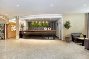 duas pessoas de pé numa recepção no átrio do hotel em H4 Hotel Arcadia Locarno em Locarno
