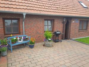 a patio with a blue bench with flowers and plants at "Alte Schmiede" in Nordenham