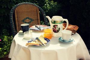 Hotel La Posada de Lalola في Buera: طاولة مع وعاء الشاي وأطباق الطعام