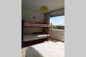 een slaapkamer met 2 stapelbedden en een raam bij Appartement Residentie Astrid met private parking in Bredene