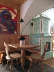 une salle à manger avec une table, des chaises et une cheminée dans l'établissement Hotel Salvanel, à Cavalese