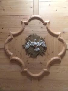 a wooden door with an eagle on the wall at Hotel Salvanel in Cavalese
