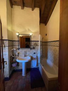 a bathroom with a sink and a bath tub at Posada Los Cantaros in Pizarra