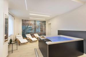 a bathroom with a hot tub in a room with chairs at Podere Vasella - Panoramic attic in Capranica