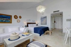 ソトグランデにあるalemaison Sotogrande Port- On the beachのリビングルーム(白いソファ、ベッド付)