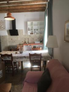 a living room with a table and chairs and a kitchen at El Molino del Corcho in Cazalla de la Sierra