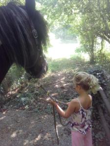 Una bambina che tiene un cavallo con una corda di Gite Ramana a Montcléra