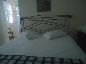 a bed with a metal headboard and two pillows at Balcony to Aegeon 1 in Apollon